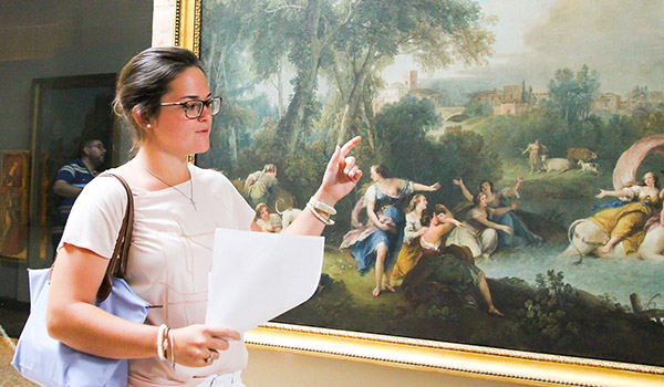 Catholic ҽ students explaining a painting.